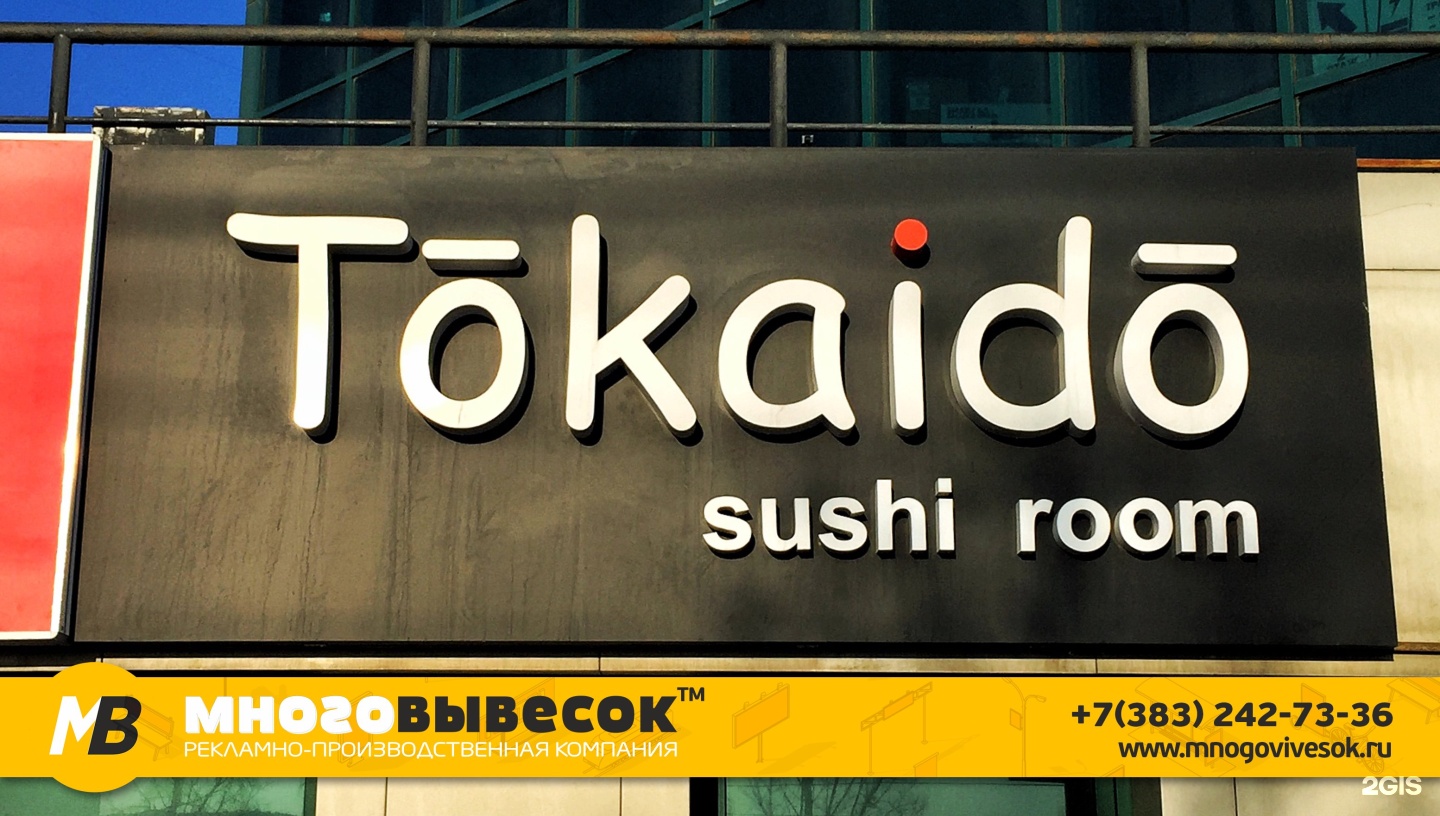 много рекламы на здании. засилье рекламы в городе. рекламные вывески на фасаде многоквартирного дома. много вывесок. много рекламы на здании.